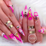 Pink and white Stiletto nails with gold embellishments