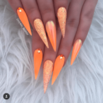 Orange Acrylic and glitter stiletto nails